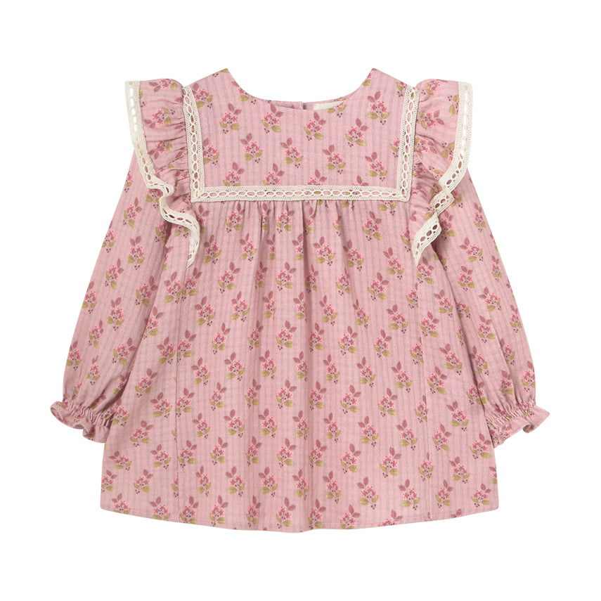 Isquia Dress from Cozmo. Pink long-sleeved dress with smocked cuffs and all-over floral print for babies. The dress has lace detailed shoulder ruffles and yokes.